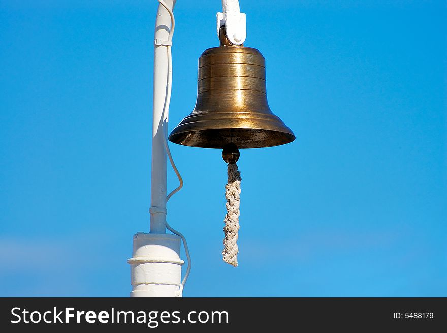 Brass ship's bell with thick rope hanging. Brass ship's bell with thick rope hanging