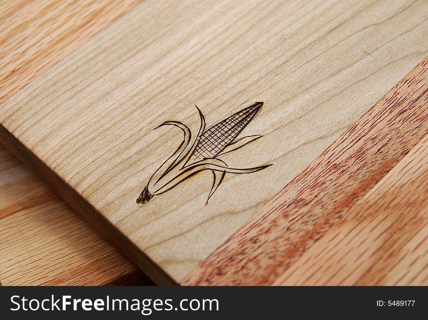 Closeup image of an ear of corn on a hardwood cutting board. Closeup image of an ear of corn on a hardwood cutting board