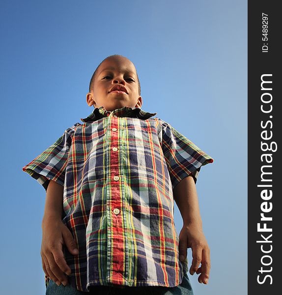 Low angle shot taken of a young boy looking down making him look like a giant. Low angle shot taken of a young boy looking down making him look like a giant.