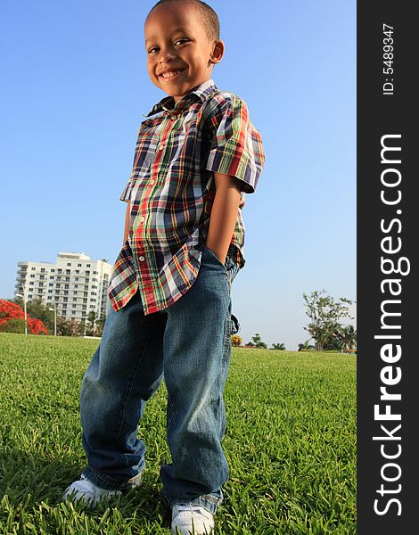 Young fashionable child posing on the grass. Young fashionable child posing on the grass.