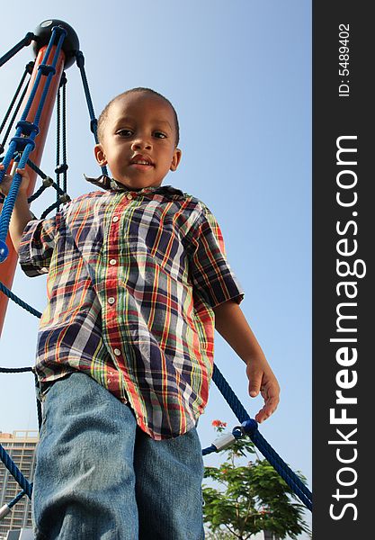 Young boy climbing to the top of a rope tower. Young boy climbing to the top of a rope tower.