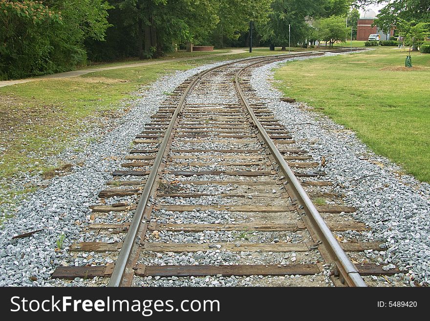 A set of vintage railroad tracks leading through rural area.