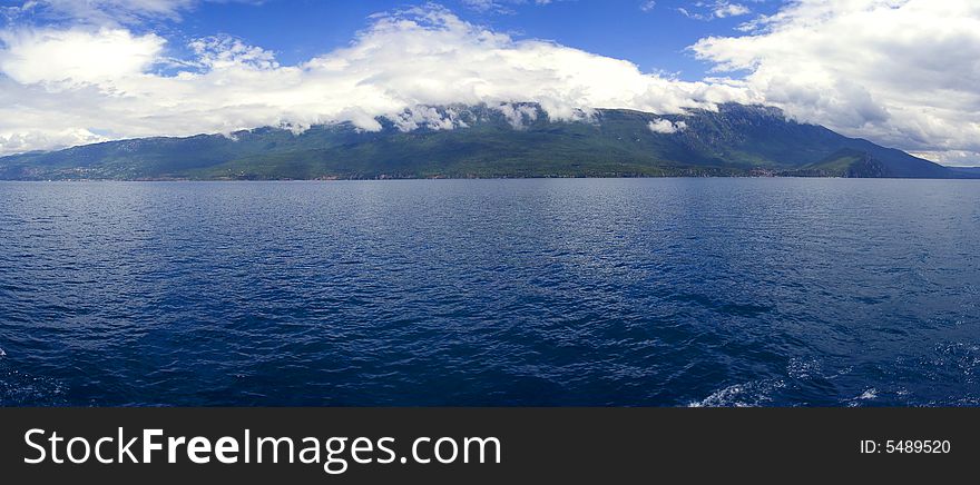 The lake drains an area of around 2600 kmÂ² and is fed primarily by underground springs on the eastern shore (about 50% of total inflow), with roughly 25% shares from rivers and direct precipitation. Over 20% of the lake's water comes from nearby Lake Prespa, about 10 km (6 miles) to the southeast and at 150 m higher altitude than Lake Ohrid. The water leaves Lake Prespa trickling through underground watercourses in the karstic landscape, where it is joined by mountain range precipitation and eventually emerges in numerous springs along the eastern shore and below the water surface of Lake Ohrid. The water leaves Lake Ohrid by evaporation (~40%) and through its only outlet, the Black Drin River, which flows in a northerly direction into Albania and thus to the Adriatic Sea. The relatively dry, Mediterranean climate and the small drainage basin of 2600 kmÂ² (catchment/lake surface ratio of ~7) of Lake Ohrid results in a long hydraulic residence time scale of ~70 yr. The lake drains an area of around 2600 kmÂ² and is fed primarily by underground springs on the eastern shore (about 50% of total inflow), with roughly 25% shares from rivers and direct precipitation. Over 20% of the lake's water comes from nearby Lake Prespa, about 10 km (6 miles) to the southeast and at 150 m higher altitude than Lake Ohrid. The water leaves Lake Prespa trickling through underground watercourses in the karstic landscape, where it is joined by mountain range precipitation and eventually emerges in numerous springs along the eastern shore and below the water surface of Lake Ohrid. The water leaves Lake Ohrid by evaporation (~40%) and through its only outlet, the Black Drin River, which flows in a northerly direction into Albania and thus to the Adriatic Sea. The relatively dry, Mediterranean climate and the small drainage basin of 2600 kmÂ² (catchment/lake surface ratio of ~7) of Lake Ohrid results in a long hydraulic residence time scale of ~70 yr.