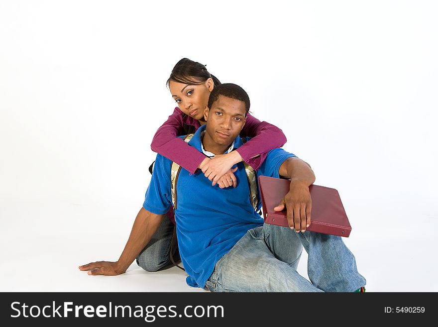 Two students looking at the camera while she has her arms around his neck. Horizontally framed photograph. Two students looking at the camera while she has her arms around his neck. Horizontally framed photograph