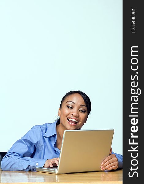 Female student laughs while looking at laptop. Vertically framed photograph. Female student laughs while looking at laptop. Vertically framed photograph