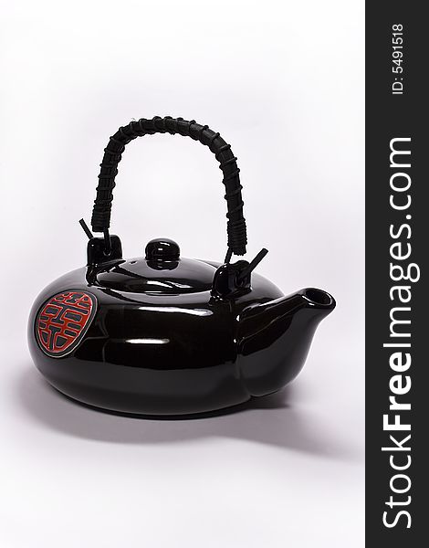 Black clay teapot from China on a white background