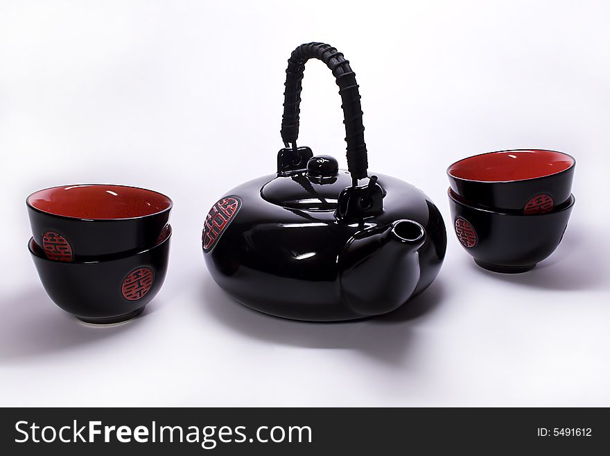 Black clay teapot and cups from China on a white background