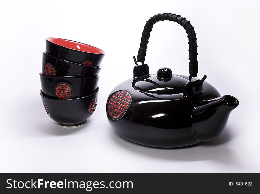 Black clay teapot and cups from China on a white background