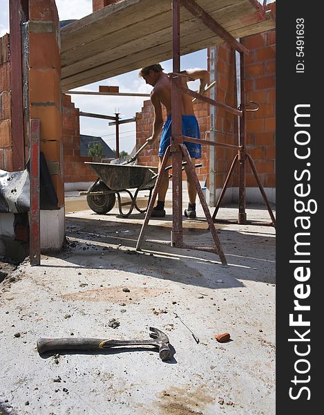 Hammer on construction site. Worker on background.