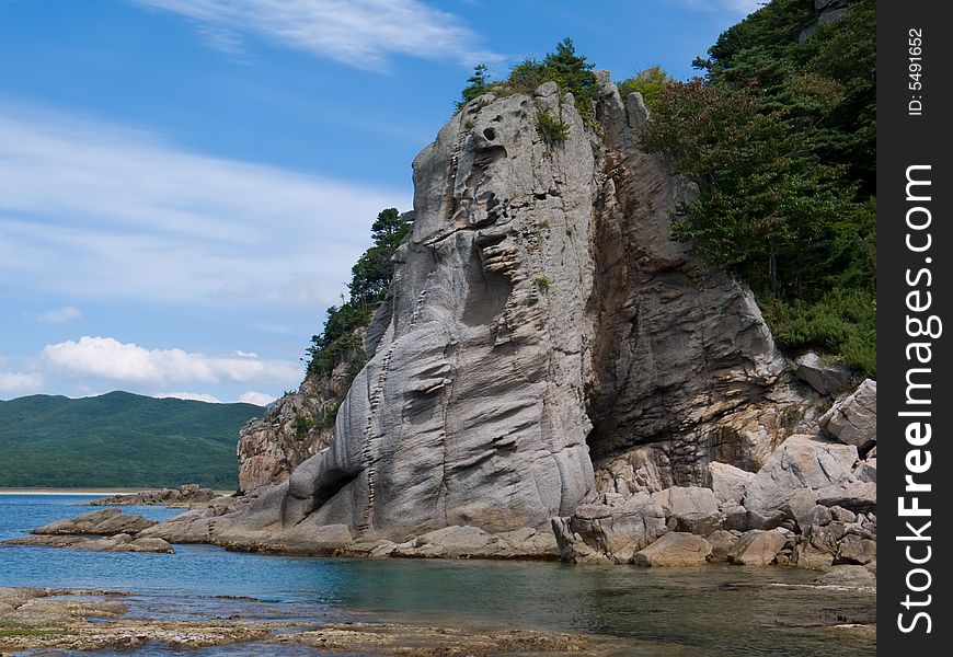 A very small bay among fancy rocks. Seacoast of Petrova island - pearl of nature state reserve Lazovsky. Russian Far East, Primorye. A very small bay among fancy rocks. Seacoast of Petrova island - pearl of nature state reserve Lazovsky. Russian Far East, Primorye.