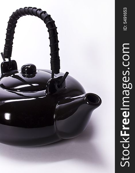 Black clay teapot from China on a white background