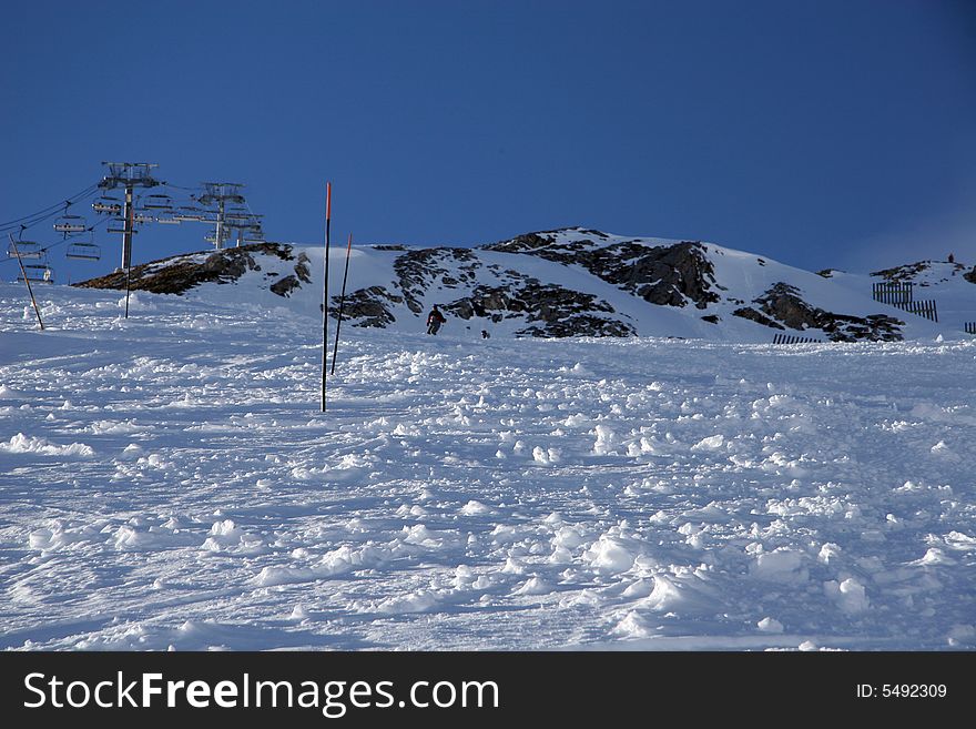 Snow slopes in a mountain with a mountain and cable chair from behind