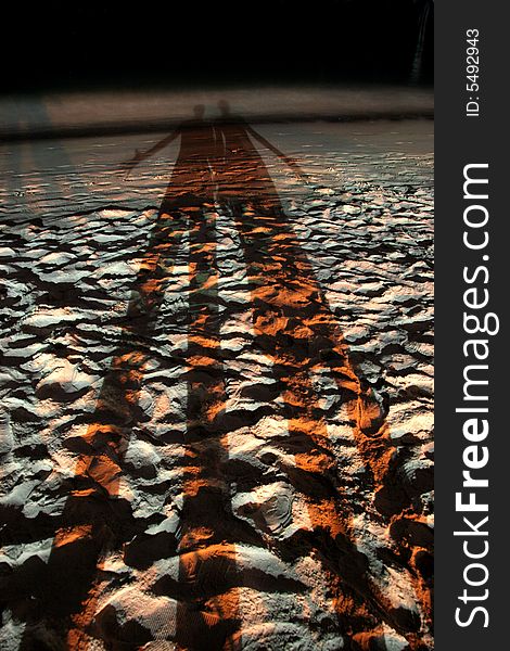 Long shadows of young couple at a beach