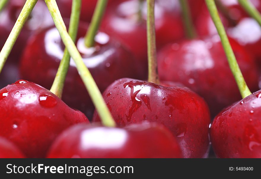 Fresh cherry with drops on background