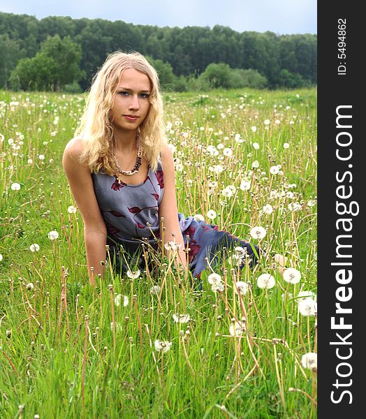 Girl sitting in dandelion