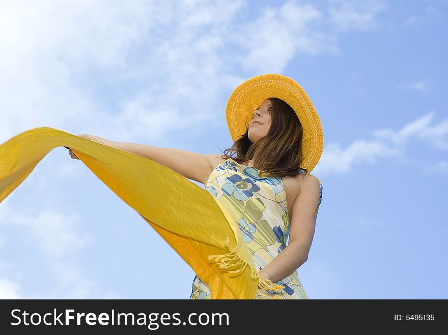 Young Woman Holding Orange Wrap Against Blue Sky