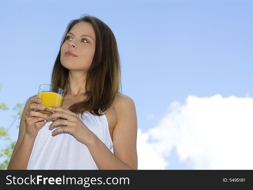 Beautiful girl drinking morning orange on balcony.