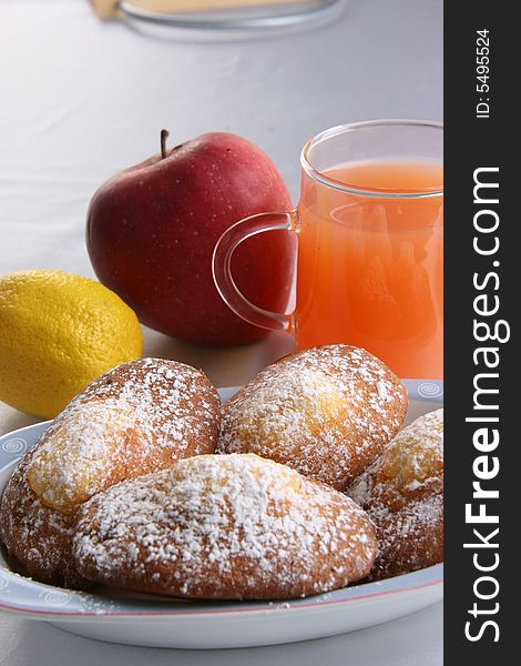 Donuts with powered sugar, juice and fruits