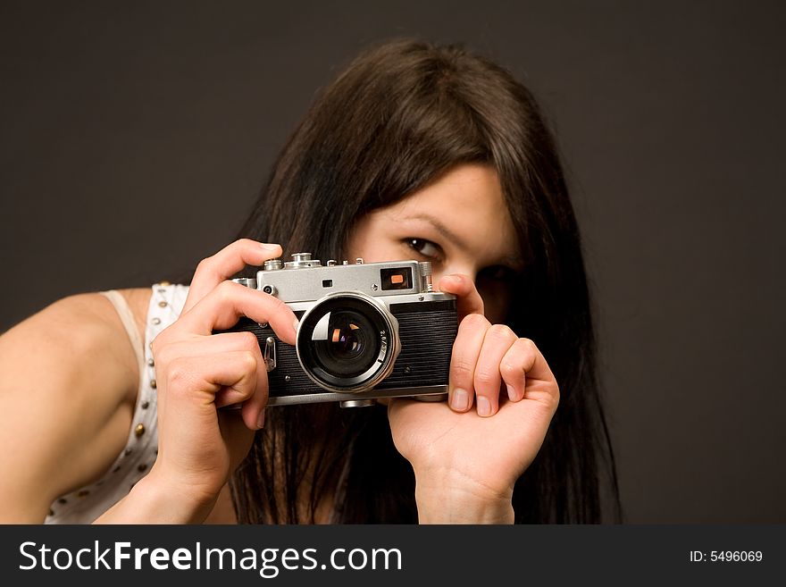 Playful girl with camera isolated on black background. Playful girl with camera isolated on black background