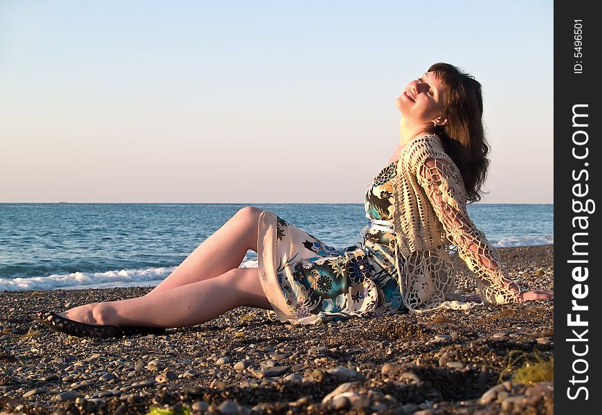 Beautiful Young Lady Sitting On Pebble