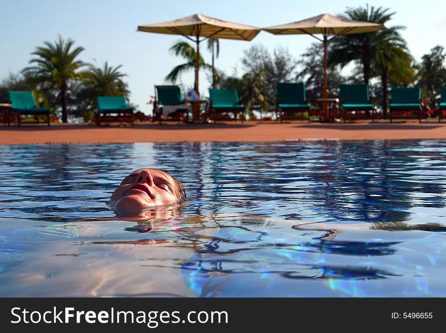 A young woman in a swimming pool. Ideal shot to express summer feeling and vacation. A young woman in a swimming pool. Ideal shot to express summer feeling and vacation.