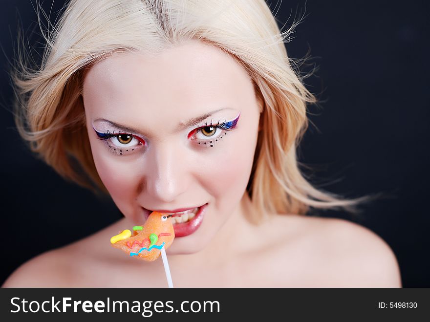 Beautiful young girl with bright make-up and lollipop in her mouth. Beautiful young girl with bright make-up and lollipop in her mouth
