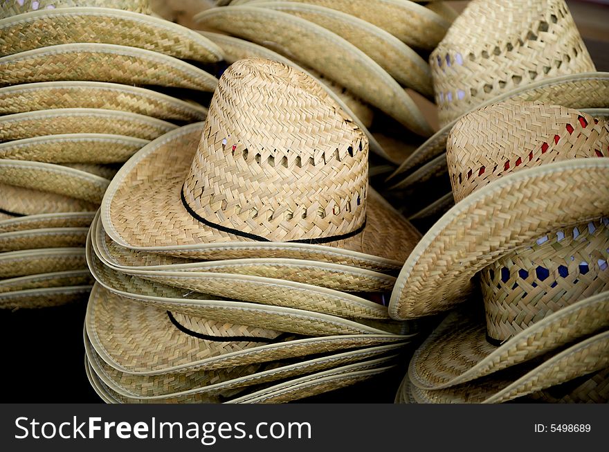 Close up image of stacked straw cowboy hats