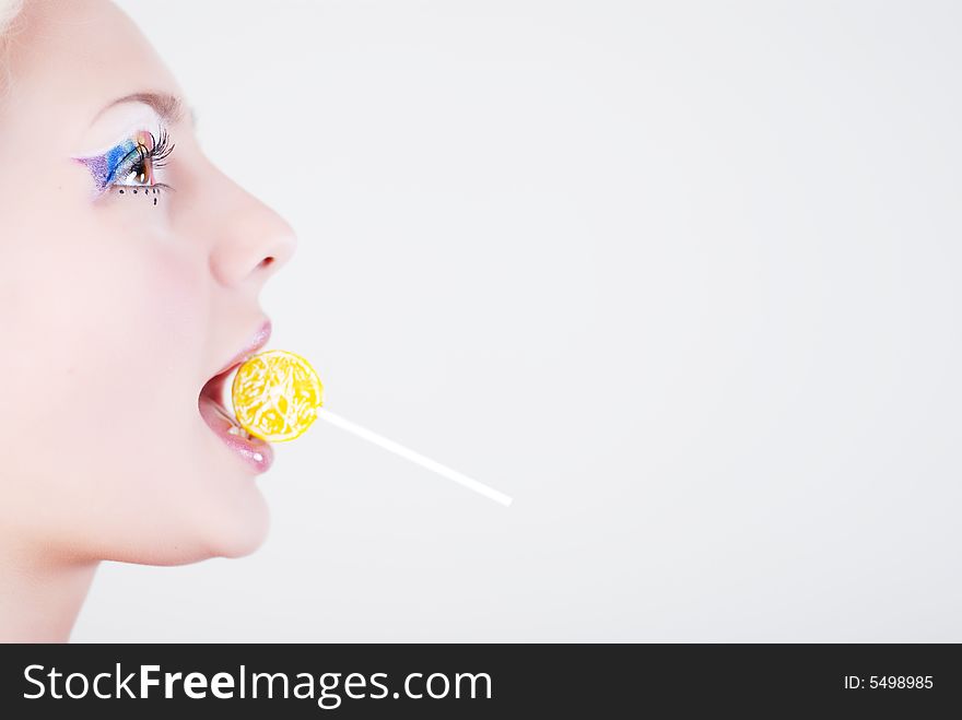 Face of beautiful girl with a lollipop in her mouth, on a white background. Face of beautiful girl with a lollipop in her mouth, on a white background