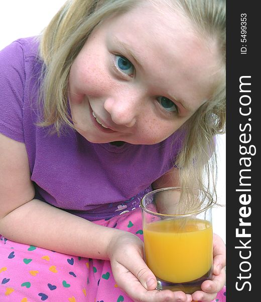 A cute little blue-eyed blond smiling and holding a glass of orange juice. A cute little blue-eyed blond smiling and holding a glass of orange juice