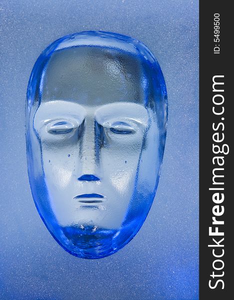 Human face in blue glass block. Human face in blue glass block