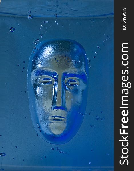 Human face in blue glass block. Human face in blue glass block