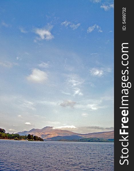 Clouds hover over a spring day in loch 
lomond in scotland. Clouds hover over a spring day in loch 
lomond in scotland