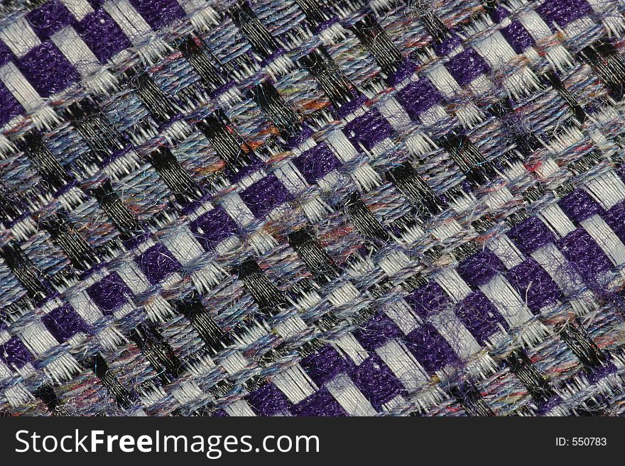 Extreme close-up of the weave of a man's tweed-style tie, revealing the secret of the fabric's subtle shades. Extreme close-up of the weave of a man's tweed-style tie, revealing the secret of the fabric's subtle shades