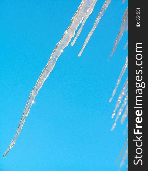 Thawing icicles on a background of the blue sky. Thawing icicles on a background of the blue sky