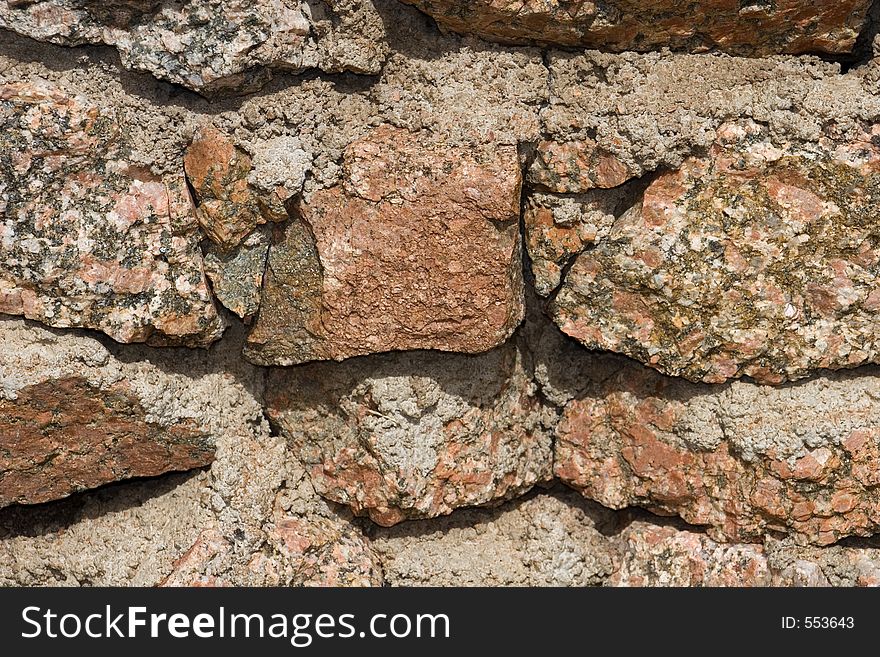 Closeup details of a moss rock wall with cement chinking for badkground uses. Closeup details of a moss rock wall with cement chinking for badkground uses