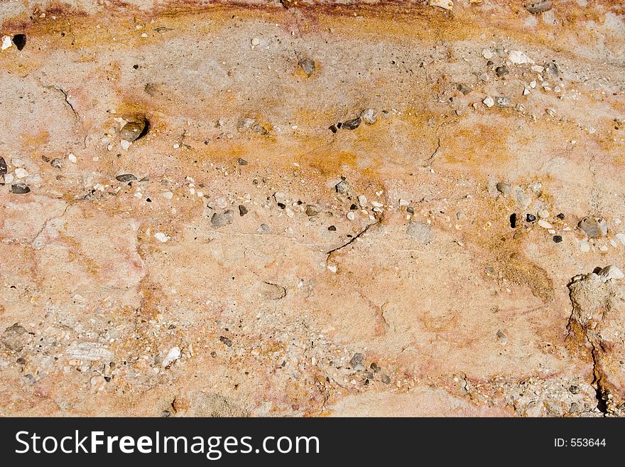 Closeup of details of a brightly colored, highly textured rock wall for background uses. Closeup of details of a brightly colored, highly textured rock wall for background uses.