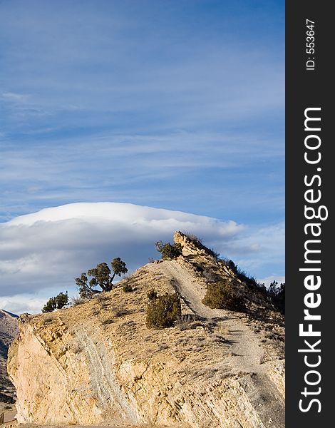 Unique rock formations slant towards the bright blue Colorado sky with unusual cloud patterns in the background. Unique rock formations slant towards the bright blue Colorado sky with unusual cloud patterns in the background.
