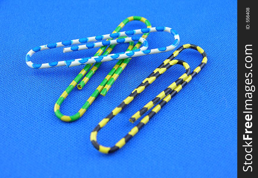 Colorful paper clips on a blue mat