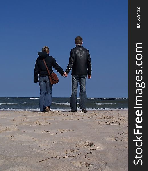 A couple is walking on the beach