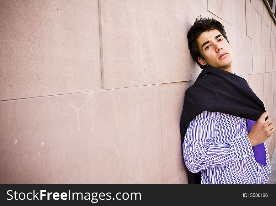 Lone businessman posing on wall. Lone businessman posing on wall