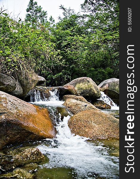 A tropical rainforest rich with fresh flowing river such as this Pisang River, making a small waterfall as it descent among the rocks on higher ground.