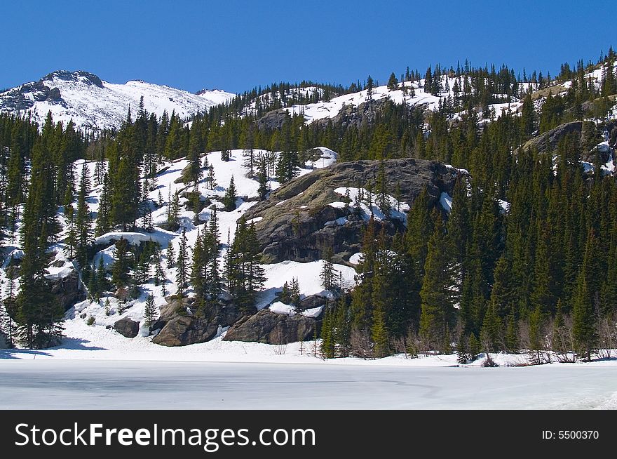 Christmas trees on a ridge above a frozen lake in Rocky Mountain National Park. Christmas trees on a ridge above a frozen lake in Rocky Mountain National Park