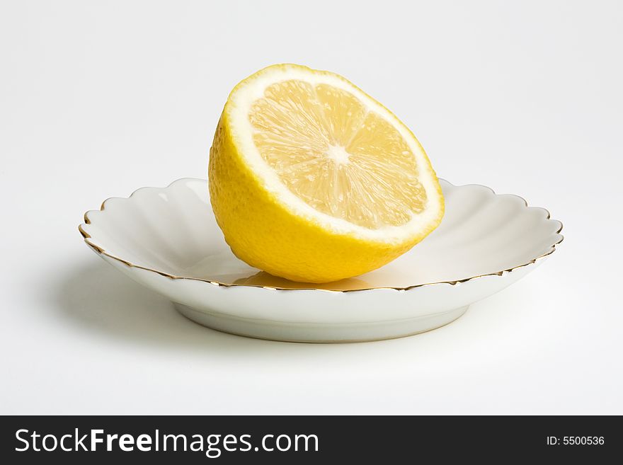 Lemon on a plate. Isolated on the white background. Clipping path included.