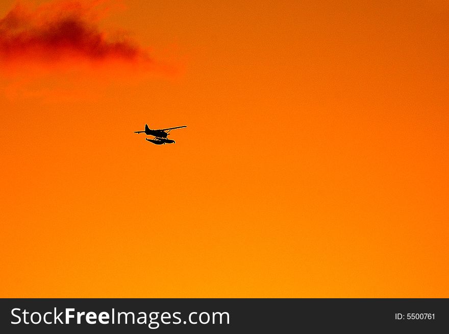 Seaplane flies towards the setting sun. Seaplane flies towards the setting sun