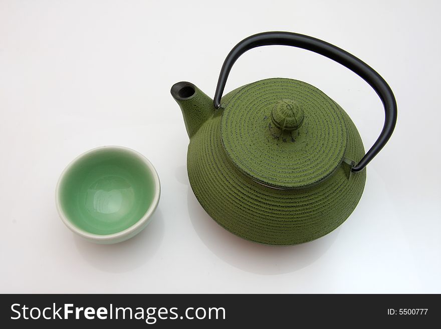 Teapot and teacup on white background.