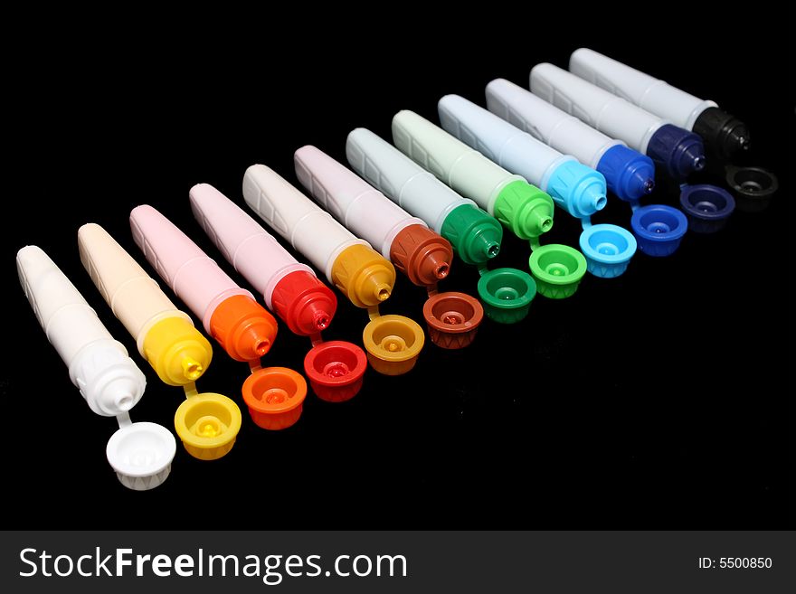 A row of colorful water colors over black background. A row of colorful water colors over black background.