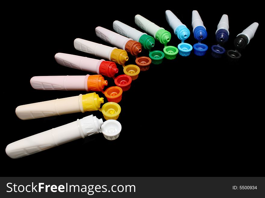 A row of colorful water colors over black background. A row of colorful water colors over black background.