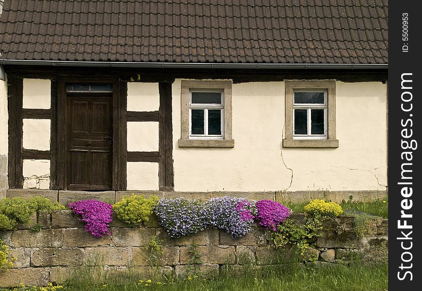 Old farmhouse with flowers in front of the door
