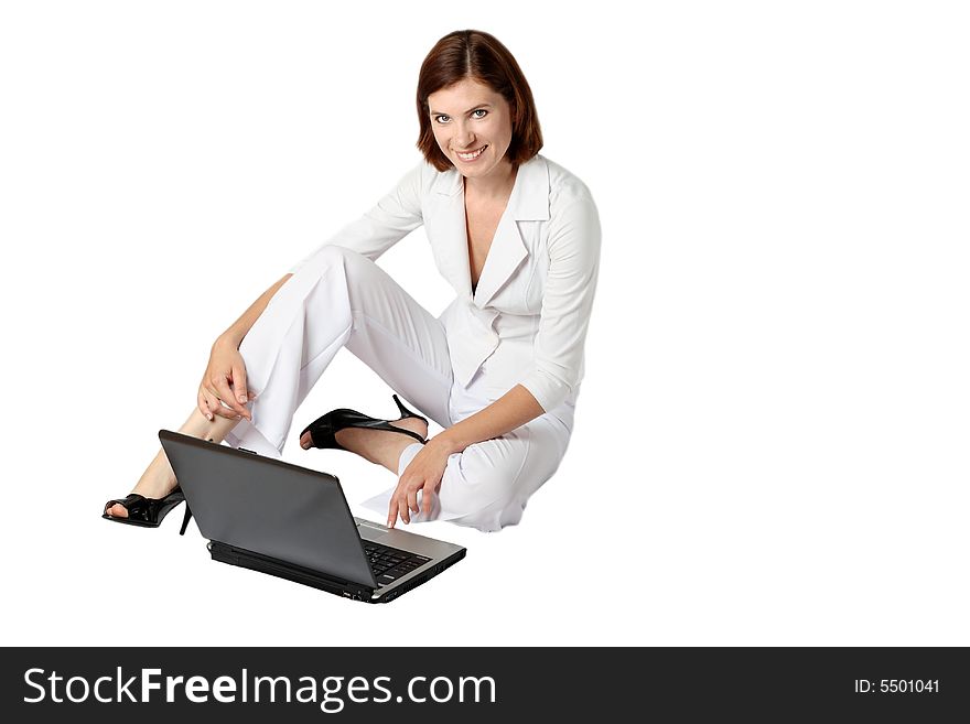 Businesswoman in white clothes sits near a laptop on a floor