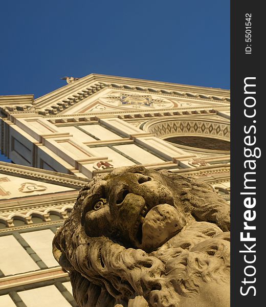 An original glimpse of the facade of Santa Croce church and a statue of a lion. An original glimpse of the facade of Santa Croce church and a statue of a lion